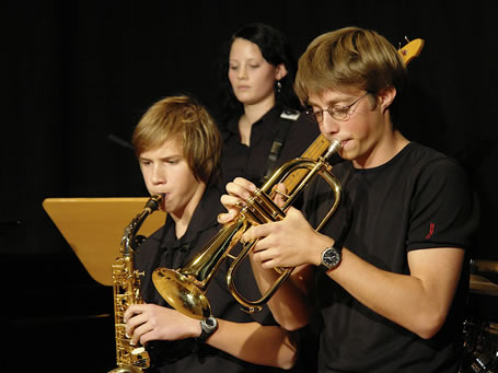 Drei junge Musiker beim Spielen ihrer Instrumente