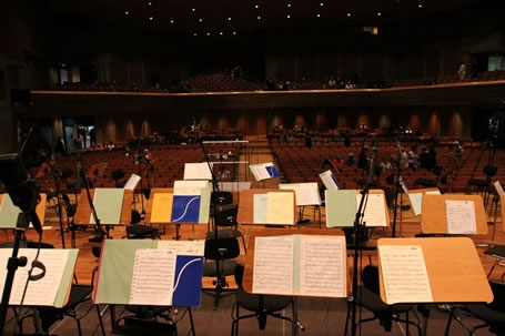 Blick von der Bühne auf die Notenständer eines Orchesters