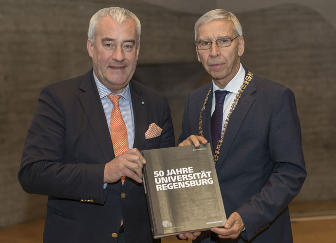 Wissenschaftsminister Dr. Ludwig Spaenle (links) nimmt ein Exemplar der Festschrift „50 Jahre Universität Regensburg