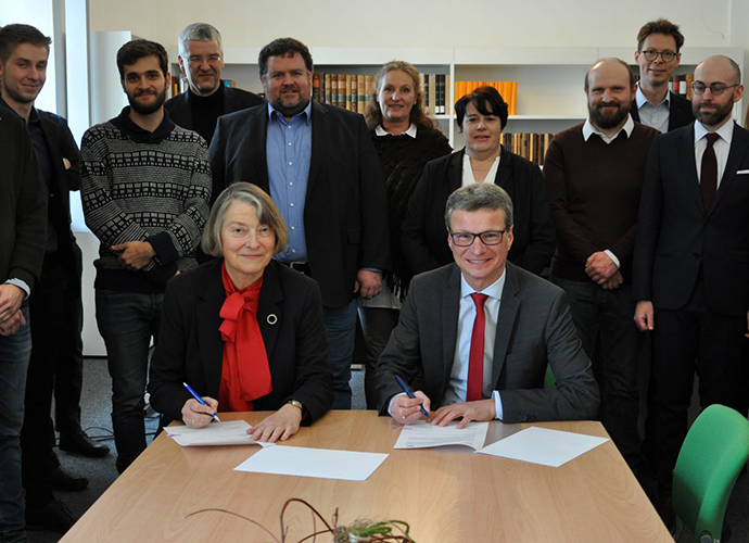 Wissenschaftsminister Bernd Sibler und die Präsidentin der MGH Prof. Dr. Martina Hartmann unterzeichnen im Institut der MGH in München im Beisein der Mitarbeiterinnen und Mitarbeiter eine gemeinsame Zielvereinbarung