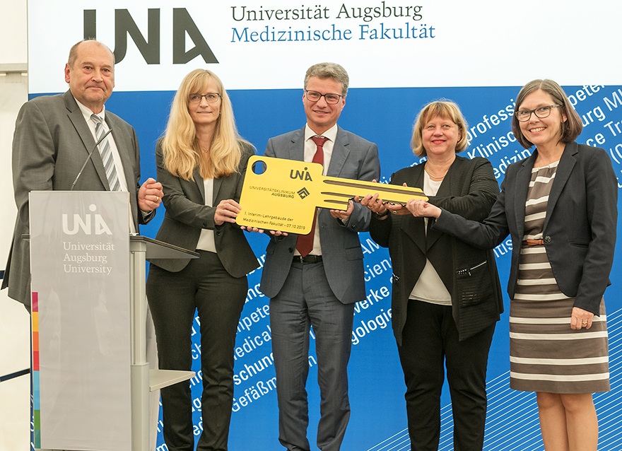 Wissenschaftsminister Bernd Sibler (Mitte) mit Ltd. Baudirektor Ulrich Blickle und Baudirektorin Annette Bubmann (beide Staatliches Bauamt Augsburg), Präsidentin Prof. Dr. Sabine Doering-Manteuffel und Prof. Dr. Martina Kadmon, der Gründungsdekanin der Medizinischen Fakultät (v.l.n.r.)