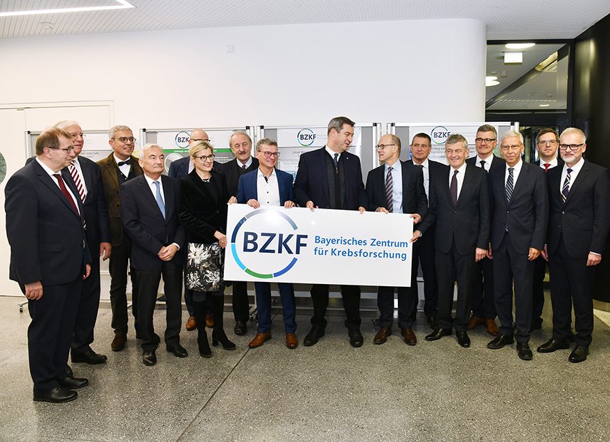 Ministerpräsident Dr. Markus Söder (9.v.l.) und Wissenschaftsminister Bernd Sibler (8.v.l.) sowie Vertreter der sechs bayerischen Universitätsklinika halten gemeinsam das Logo des BZKF im Foyer des Translational Research Center (TRC) des Uni-Klinikums Erlangen