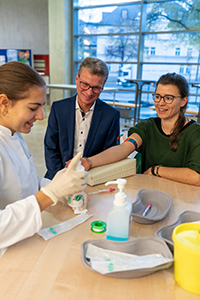Wissenschaftsminister Bernd Sibler bei der Typisierung einer Studentin