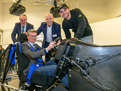 Wissenschaftsminister Bernd Sibler im Cockpit des aVDS mit Prof. Dr. Hauke (Präsident HAW Kempten), Prof. Dr. Bernhard Schick (Leiter des Adrive Living Lab der Hochschule Kempten) und Formel-E-Rennfahrer Daniel Abt (v.l.n.r.)