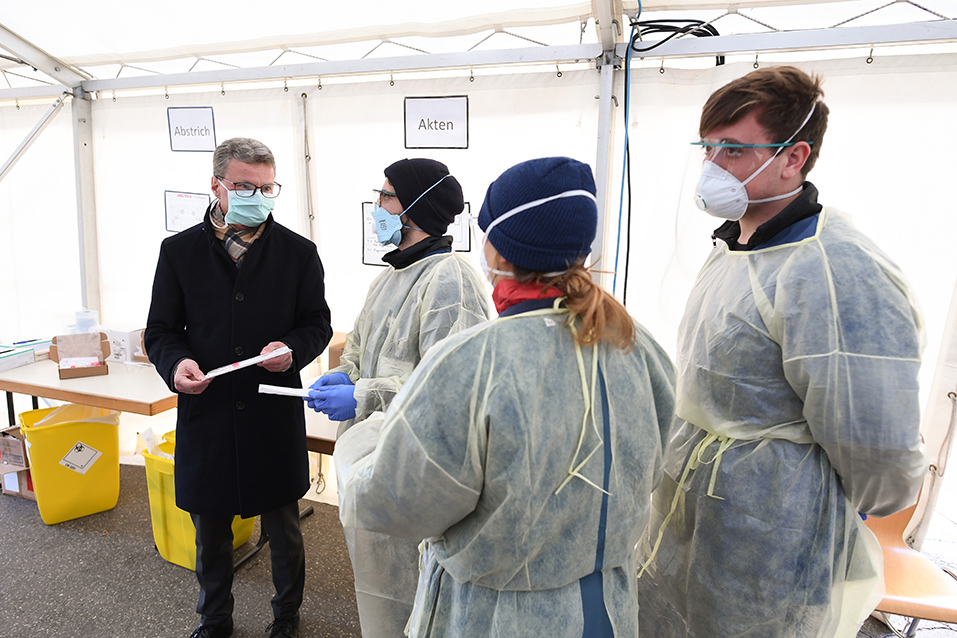 Wissenschaftsminister Bernd Sibler (l.) mit medizinischem Personal des Tropeninstituts am LMU Klinikum in der Teststation