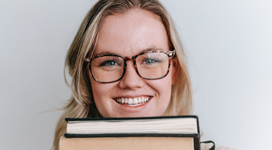 Eine junge Frau mit Büchern (© pexels/George Milton)