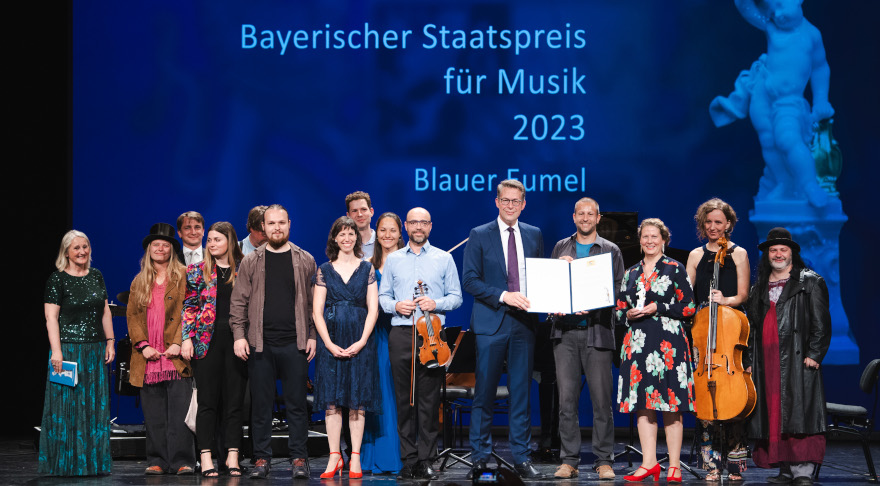 Kunstminister Markus Blume verleiht den Staatspreis für Musik an das Ensemble „Der Blaue Eumel“ (© StMWK/Andreas Gebert)
