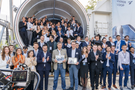 Ministerpräsident Söder und Wissenschaftsminister Blume mit dem Hyperloop-Team vor dem 24 Meter langen Testsegment (© StMWK/Wolfgang M. Weber)