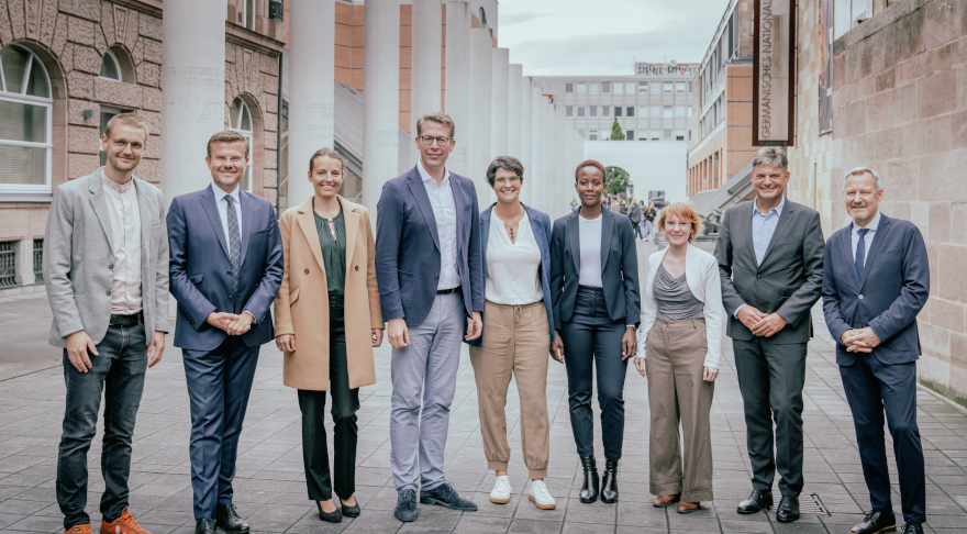 StM Blume (4. v.l.) mit OB König (2. v.l.), FAU-Präsident Prof. Dr. Hornegger (2. v.r.), dem wissenschaftl. Leiter des Zentrums Dr. Krennerich (rechts), Co-Sprecherin Prof. Dr. Farahat (Mi.) und Post-Docs aus der Menschenrechtsforschung (© Axel König)