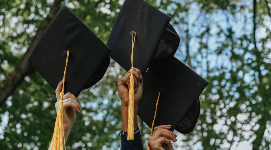 Akademische Abschlusskappen werden in die in die Luft gehalten (© Pexels/Olia Danilevic)