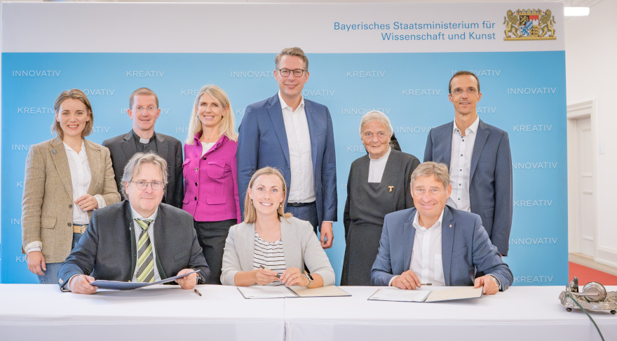 Kunstminister Blume (2.R.3.v.r) mit Beteiligten an der Bayerischen Landesausstellung 2027 „Schwesterherz! Frauen retten Bayern“ bei der Unterzeichnung des Kooperationsvertrages (© Axel König/StMWK)