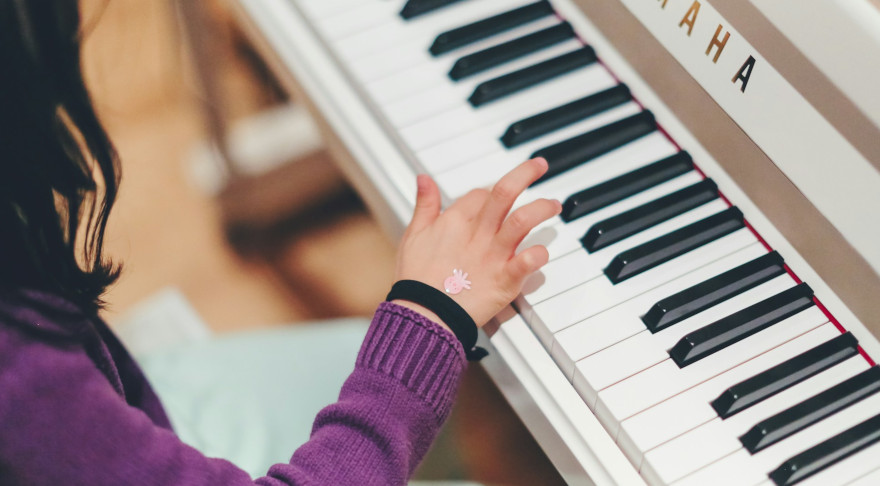Ein Mädchen spielt Klavier (© Siniz Kim/Unsplash)