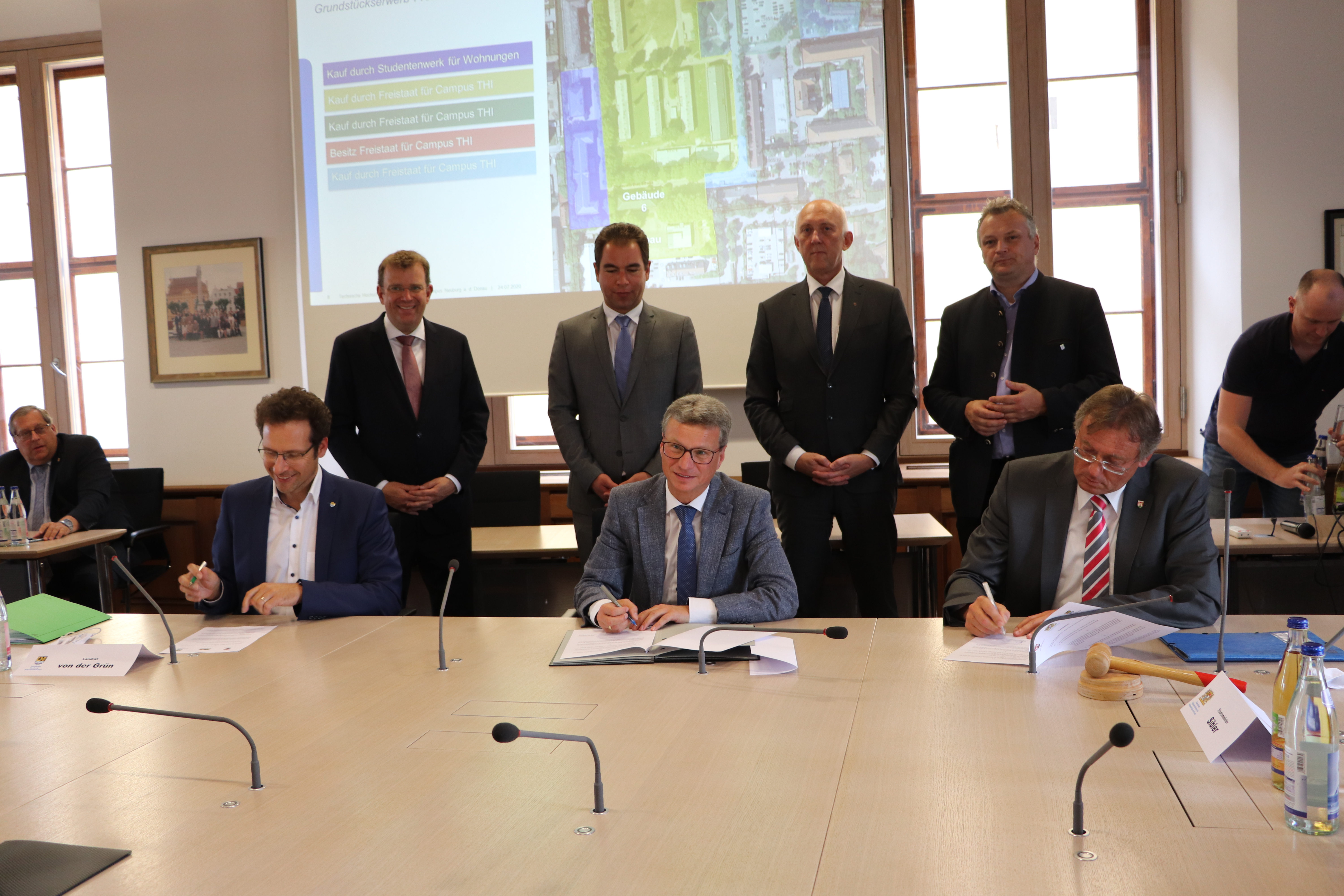 Wissenschaftsminister Bernd Sibler (Mitte) unterzeichnet mit Landrat Peter von der Grün (vorne l.) und Oberbürgermeister Dr. Bernhard Gmehling (vorne r.) eine Vereinbarung zwischen Freistaat, Landkreis und Stadt zum neuen Campus in Neuburg