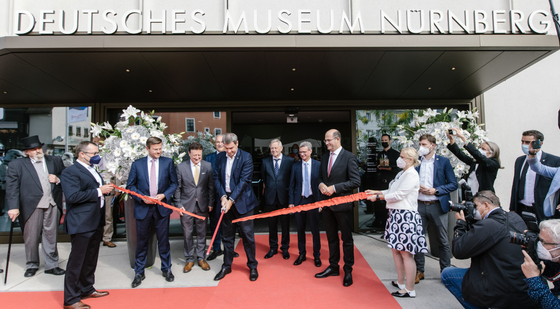 Wissenschaftsminister Bernd Sibler (8.v.l.) und weitere Ehrengäste beim Durchtrennen des roten Bandes durch Ministerpräsident Dr. Markus Söder (Mi.)