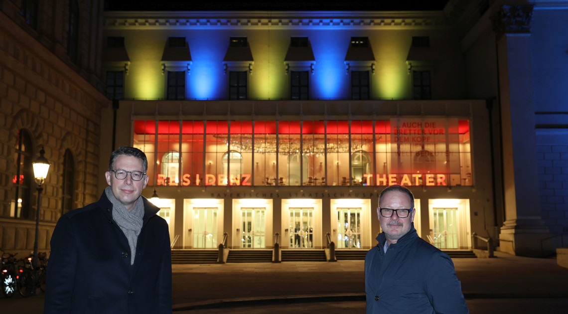 Zeichen der Solidarität: Kunstminister Markus Blume (l.) mit Staatsintendant Andreas Beck am 25.02.2022 vor dem in den Farben der Ukraine erleuchteten Residenztheater (Foto: Alexandra Beier)